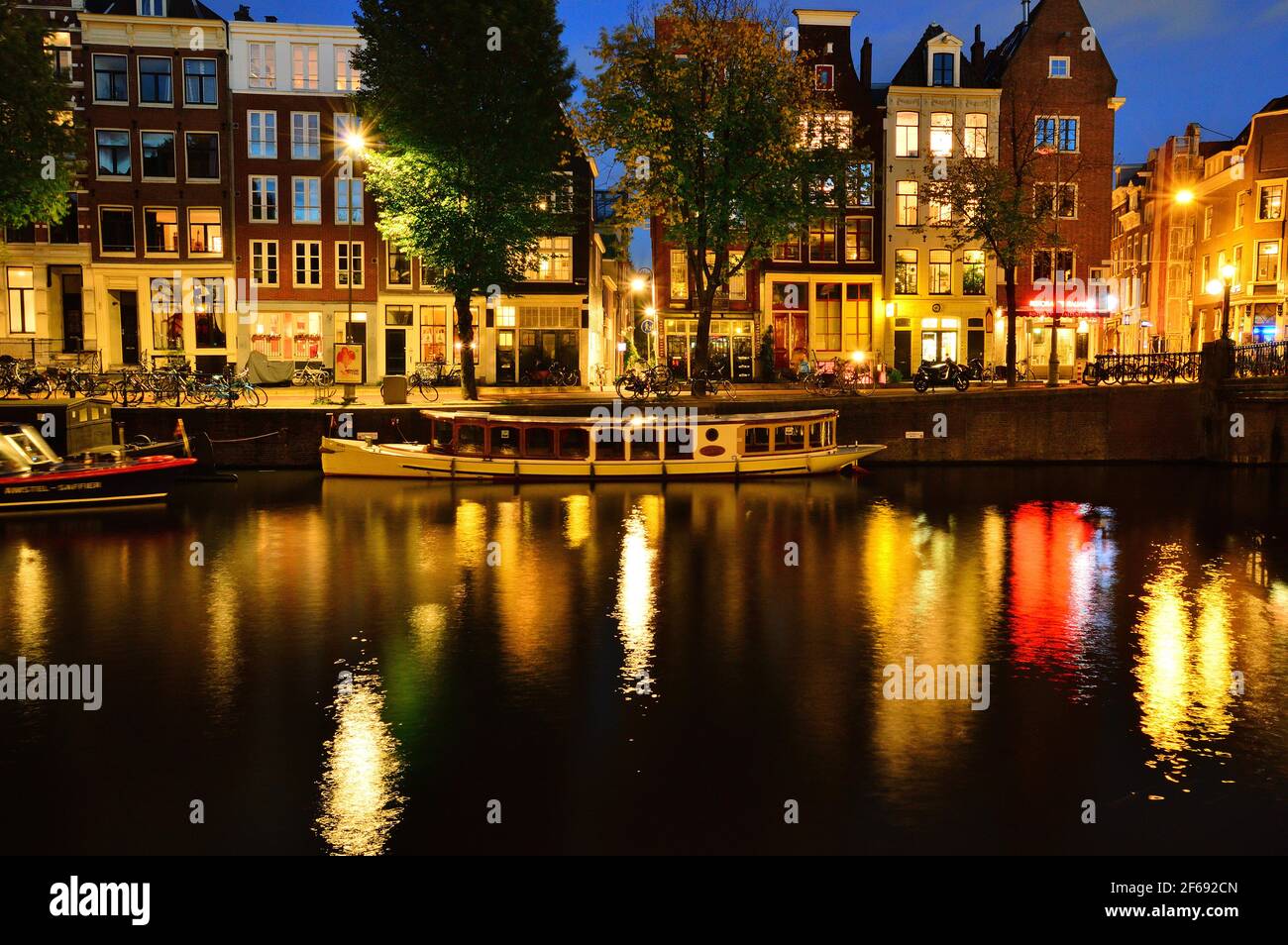 Canali ad Amsterdam, Paesi Bassi illuminati di notte con luci colorate. Foto Stock