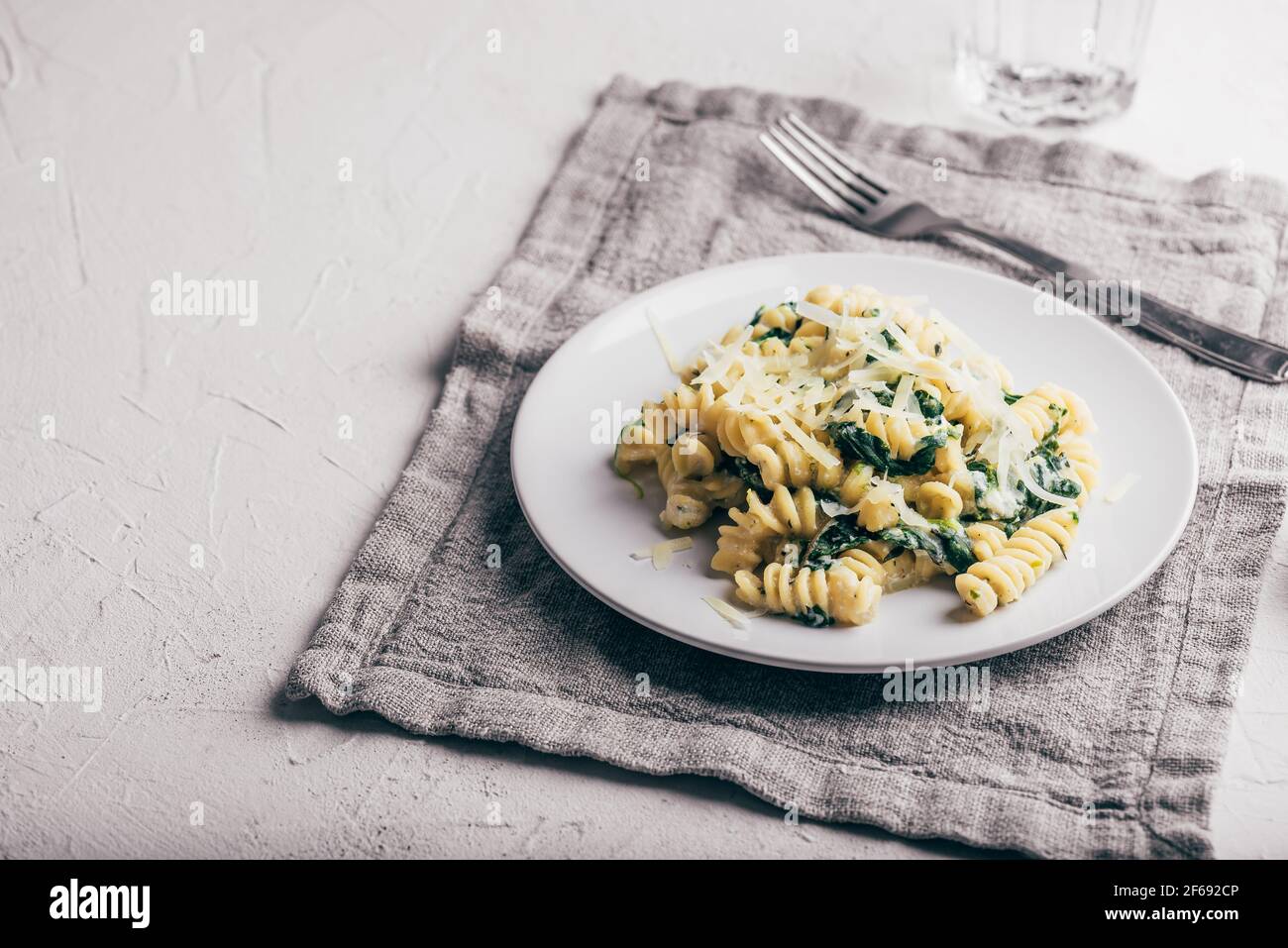 Pasta cremosa di spinaci con ricotta e parmigiano su piatto bianco Foto Stock