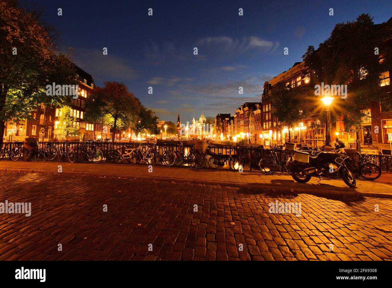 Biciclette sul ponte dei canali di Amsterdam di notte. Foto Stock