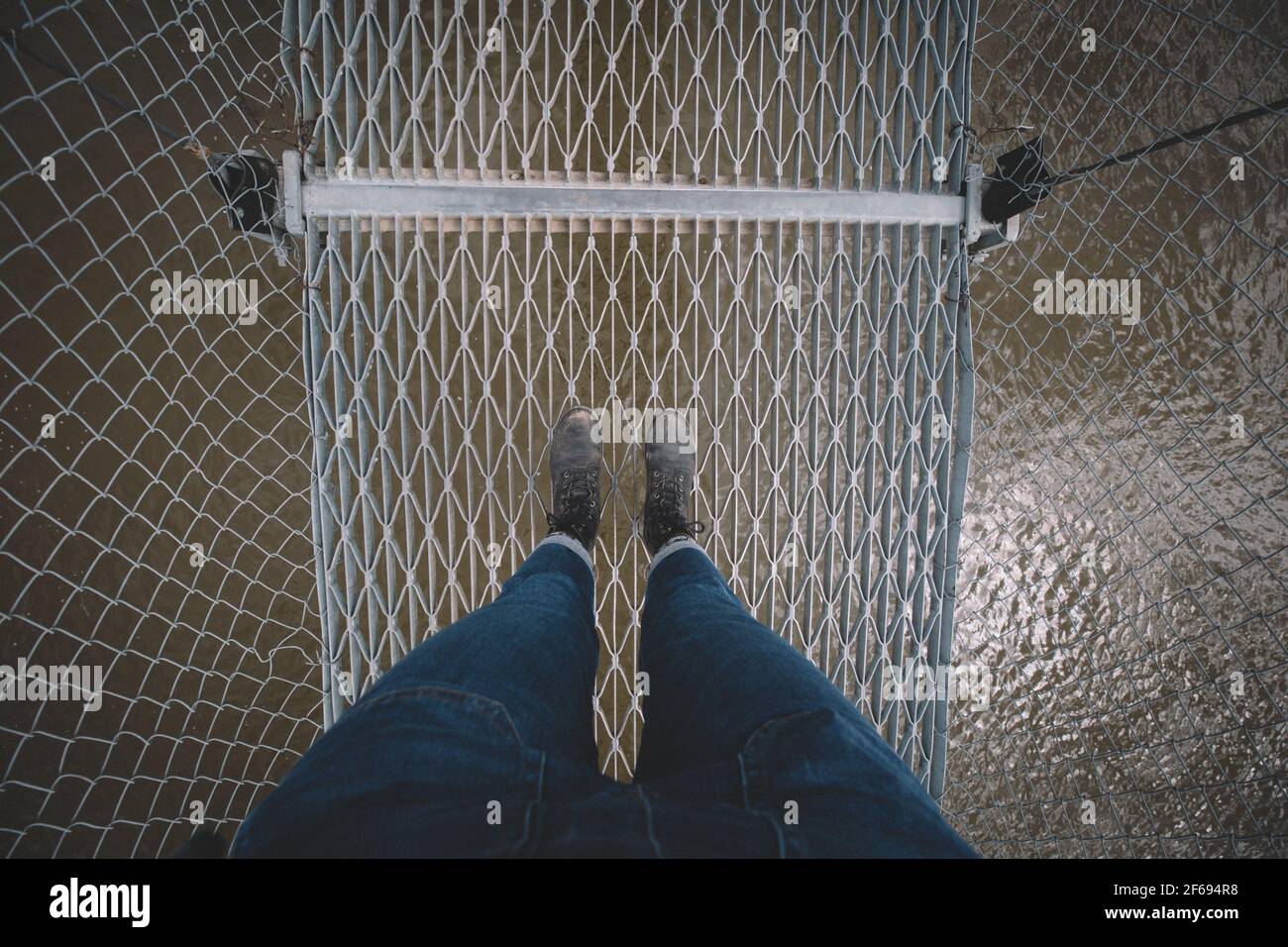 Piedi su un ponte sospeso sul Fiume Red Deer Foto Stock