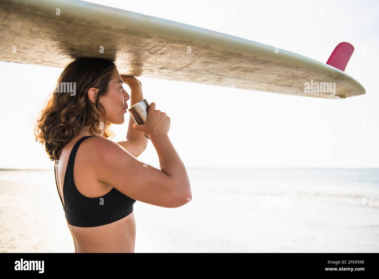 Donna che ama il caffè del mattino prima del surf Foto Stock