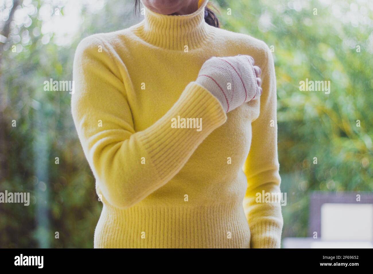 mano bendata di donna con maglione giallo Foto Stock