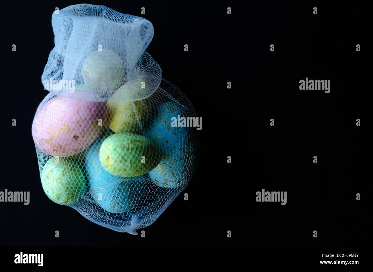 uova di pasqua colorate in una griglia su sfondo scuro, spazio libero Foto Stock