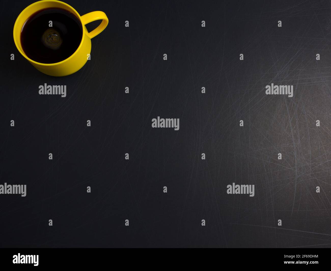 Tazza gialla, tazza di caffè nero piatto stese su fondo nero e ruvido. Consente di copiare lo spazio per il testo, l'immagine o il messaggio. Immagine orizzontale minima. Foto Stock