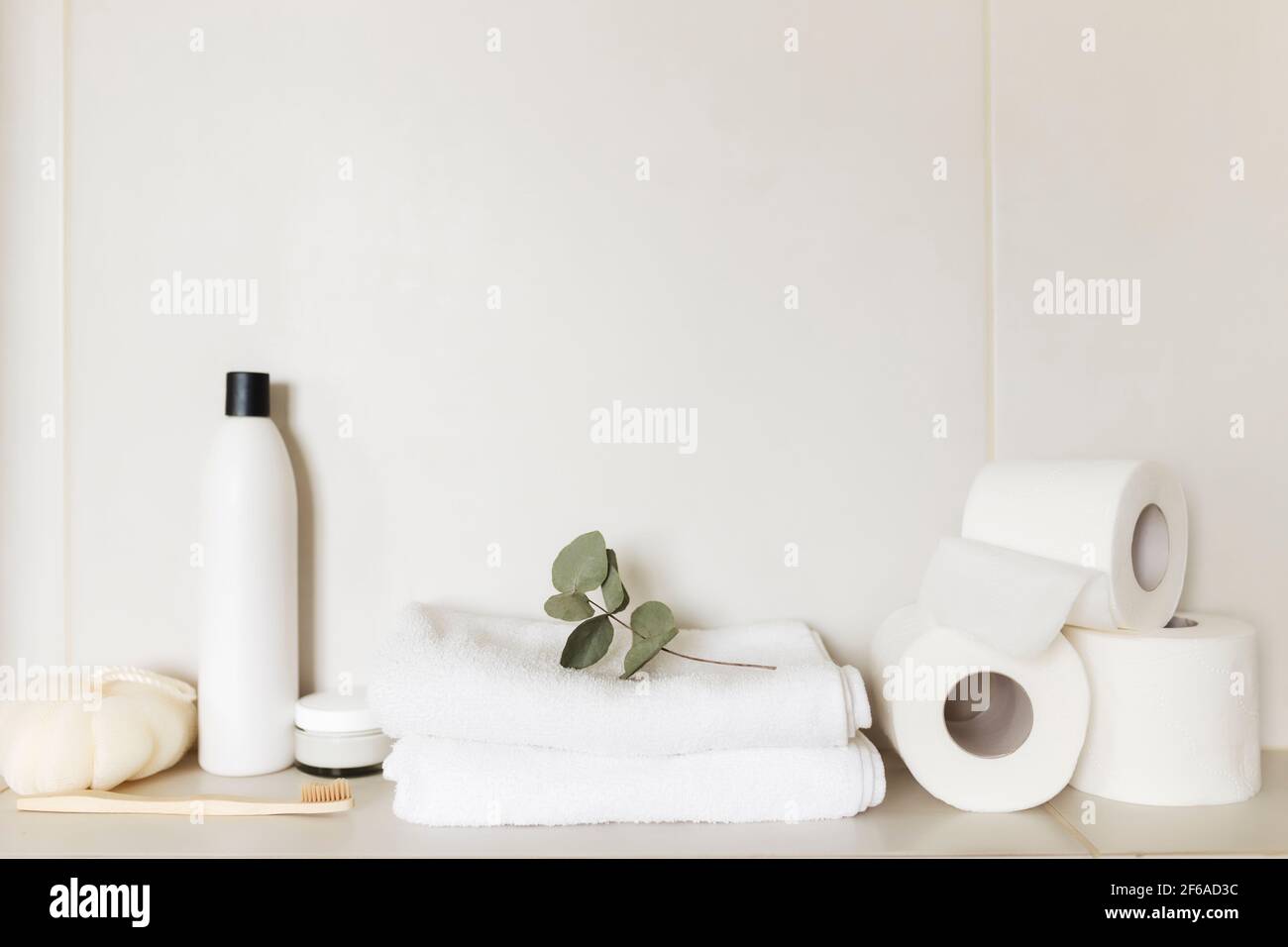 Lavabo in bagno bianco con accessori da bagno. Concetto di pulizia dell'hotel. Concetto domestico. Lavabo, shampoo, crema, carta igienica, pianta, dentifricio Foto Stock