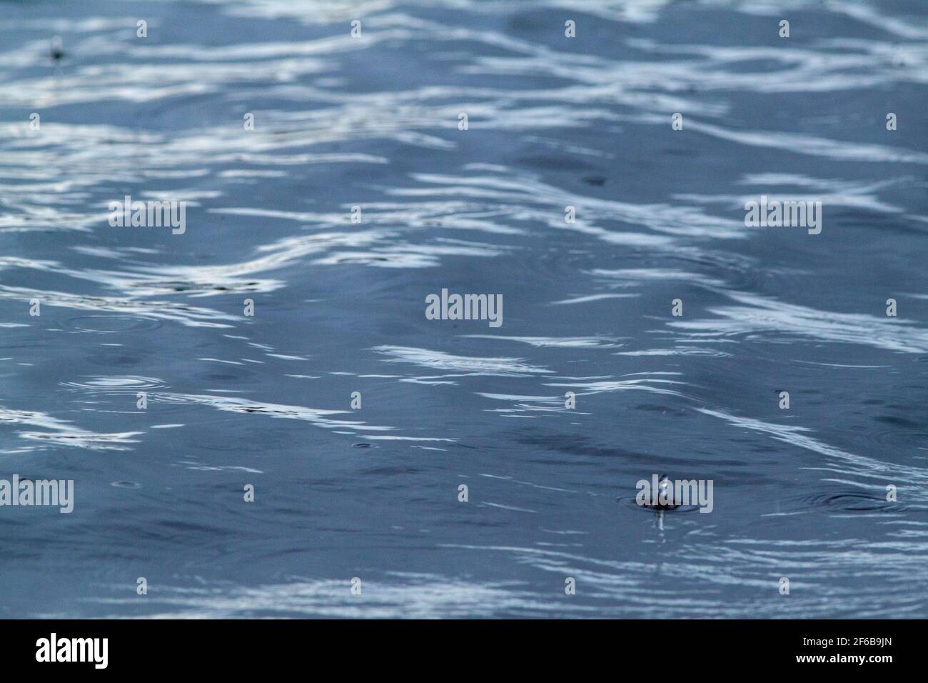 Acqua superficie, modelli, forme, creato, formato, formare, evolvere, da continue, continue, precipite su una superficie fluente blu del fiume. Foto Stock