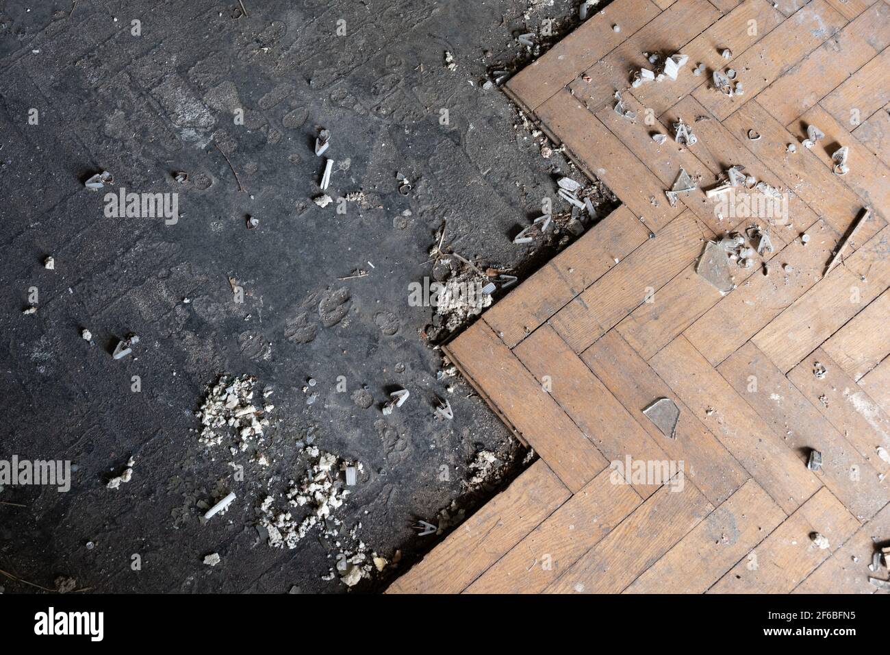 Parquet pavimento in legno, pavimento vecchio sporco, metà di esso coperto con tavole di legno in una stanza abbandonata edificio Foto Stock