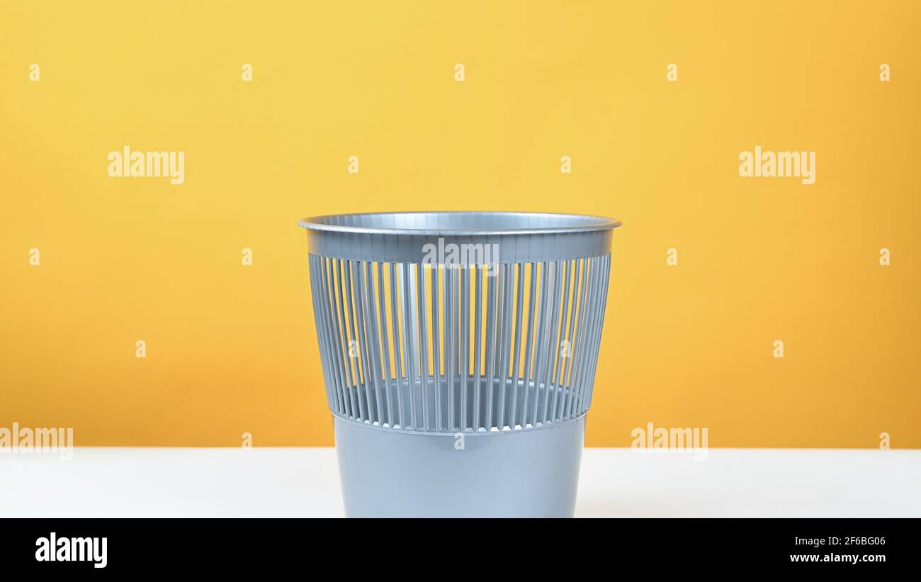 cestino grigio su sfondo giallo Foto Stock