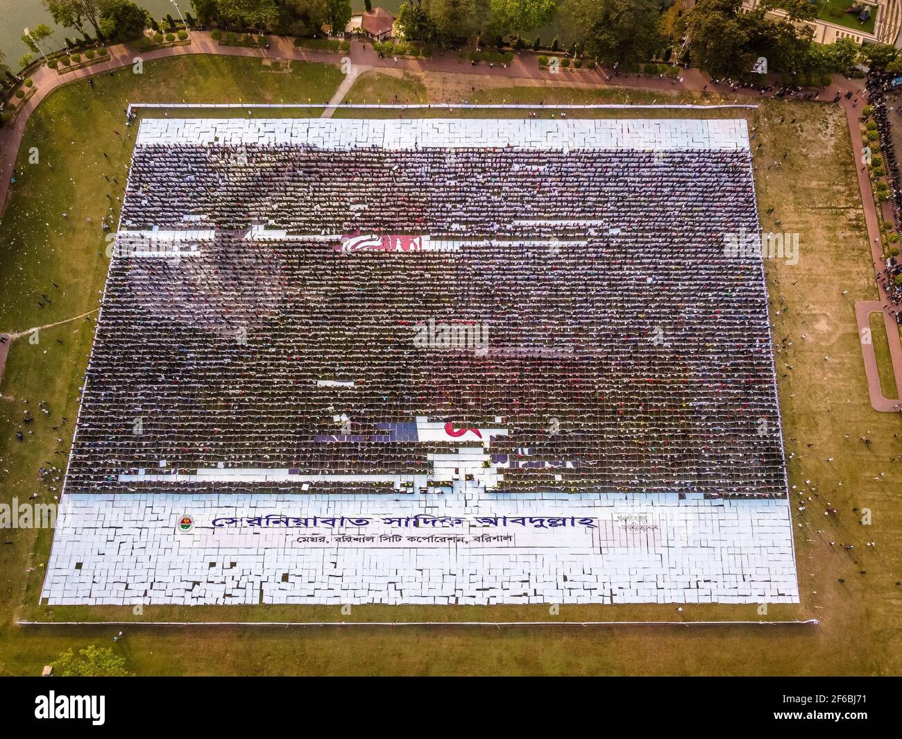Le persone di Barisal, una città del Bangladesh, hanno realizzato il più grande logo umano in più di 60,000 metri quadrati di area campo per celebrare il 100 ° anno di nascita del Padre della nazione, "Bangabandhu, Sheikh Mujibur Rahman il 30 marzo 2021. Totale 10,050 cartelloni in totale 120 linee, ciascuna delle quali è composta da 84-85 cartelloni, sono utilizzati per realizzare il logo umano più lungo e più grande. Minimo 100-120 lavoratori hanno lavorato duramente fino a 12-13 giorni per fare questo logo gigante e circa 10000 persone si sono levate in piedi alla volta con i cartelli nelle loro mani per rendere il logo con successo per essere visibile. (Foto di Mustasinur Foto Stock