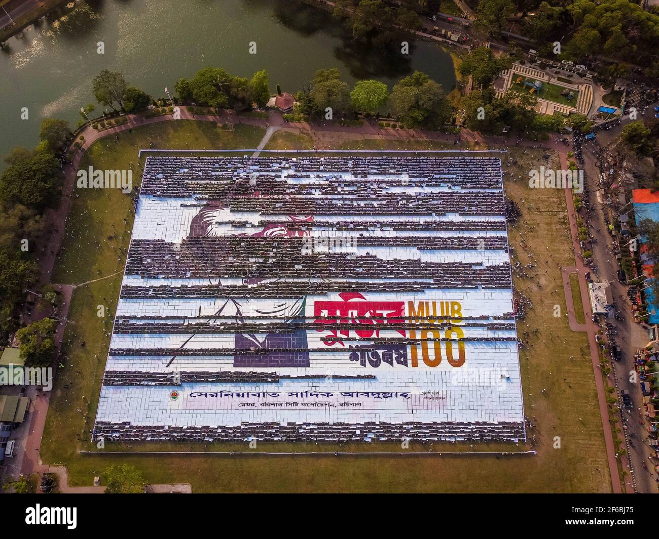 Le persone di Barisal, una città del Bangladesh, hanno realizzato il più grande logo umano in più di 60,000 metri quadrati di area campo per celebrare il 100 ° anno di nascita del Padre della nazione, "Bangabandhu, Sheikh Mujibur Rahman il 30 marzo 2021. Totale 10,050 cartelloni in totale 120 linee, ciascuna delle quali è composta da 84-85 cartelloni, sono utilizzati per realizzare il logo umano più lungo e più grande. Minimo 100-120 lavoratori hanno lavorato duramente fino a 12-13 giorni per fare questo logo gigante e circa 10000 persone si sono levate in piedi alla volta con i cartelli nelle loro mani per rendere il logo con successo per essere visibile. (Foto di Mustasinur Foto Stock