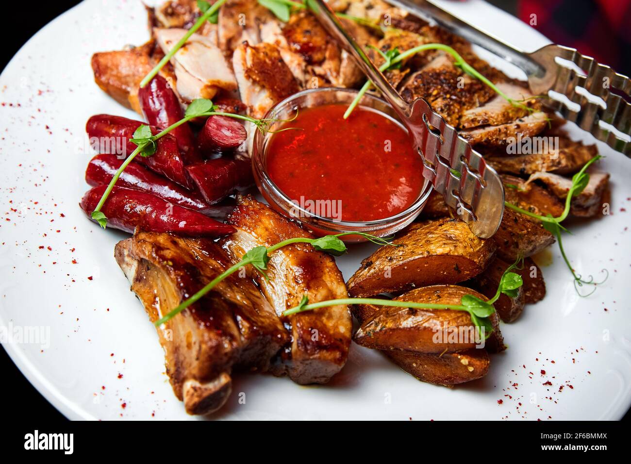 Carne con bistecche di maiale e pollo, salsicce da caccia, costolette di maiale e salsa kebab. Primo piano, messa a fuoco selettiva Foto Stock