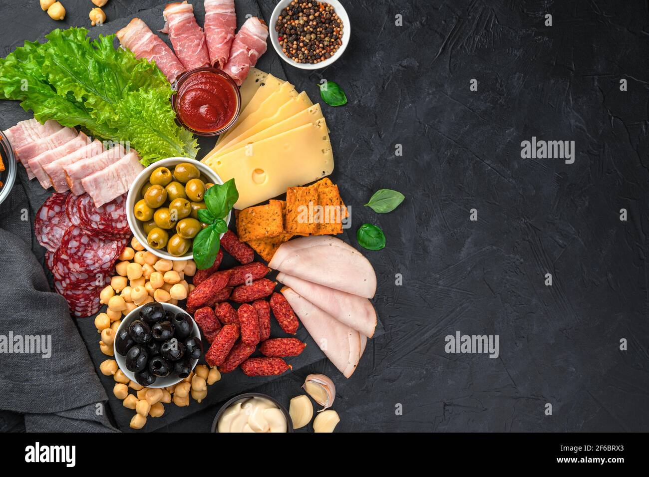 Una tavola di antipasti con salumi e formaggi. Salsiccia, prosciutto, olive, formaggio e cracker per il buffet. Foto Stock