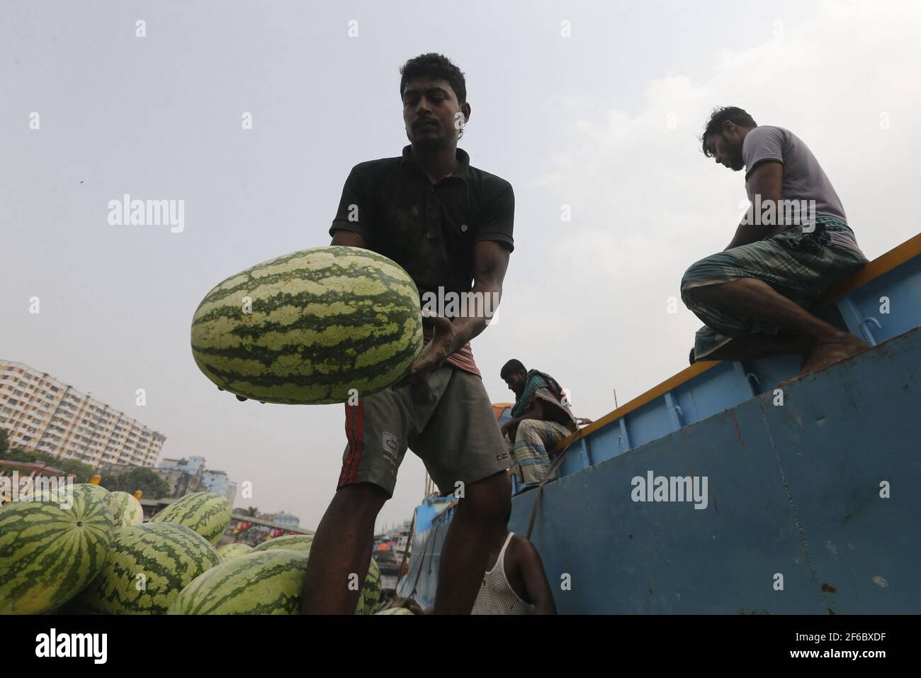 I lavoratori del Bangladesh scaricano il melone dalle imbarcazioni di Sadarghat a Dhaka, Bangladesh, il 30 marzo 2021. Foto di Suvra Kanti Das/ABACAPRESS.COM Foto Stock