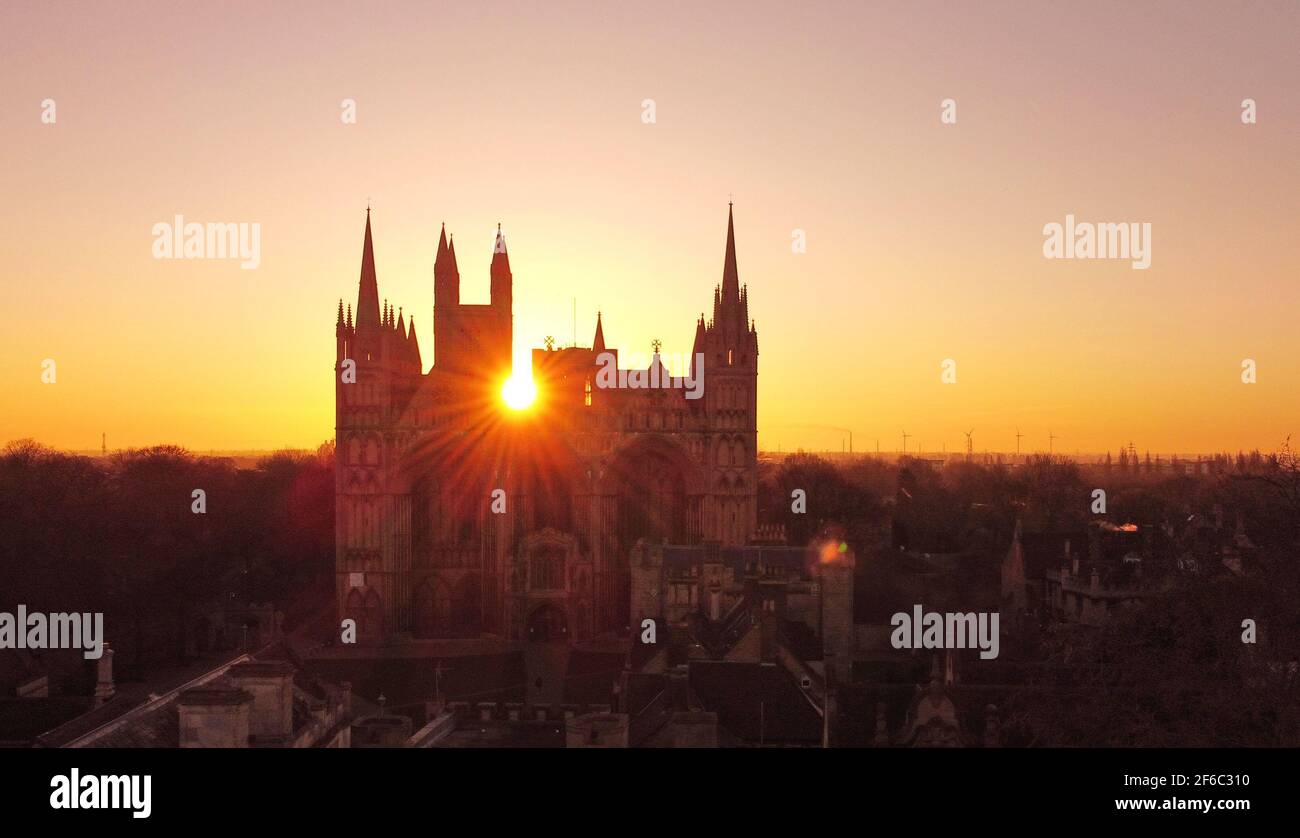 Peterborough, Regno Unito. 30 Marzo 2021. Il sole sorge dietro la Cattedrale di Peterborough, per un piacevole inizio di giornata a Peterborough, Cambridgeshire. La cattedrale è una delle più belle cattedrale normanne d'Inghilterra, risalente al 654 d.C. Credit: Paul Marriott/Alamy Live News Foto Stock