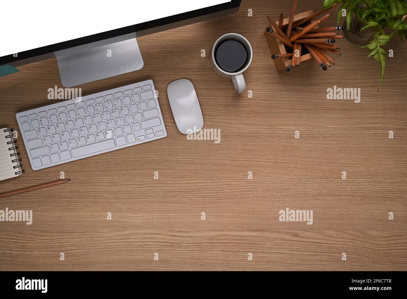 Vista dall'alto della scrivania da ufficio con computer, portamatite,  notebook e caffettiera su sfondo in legno Foto stock - Alamy