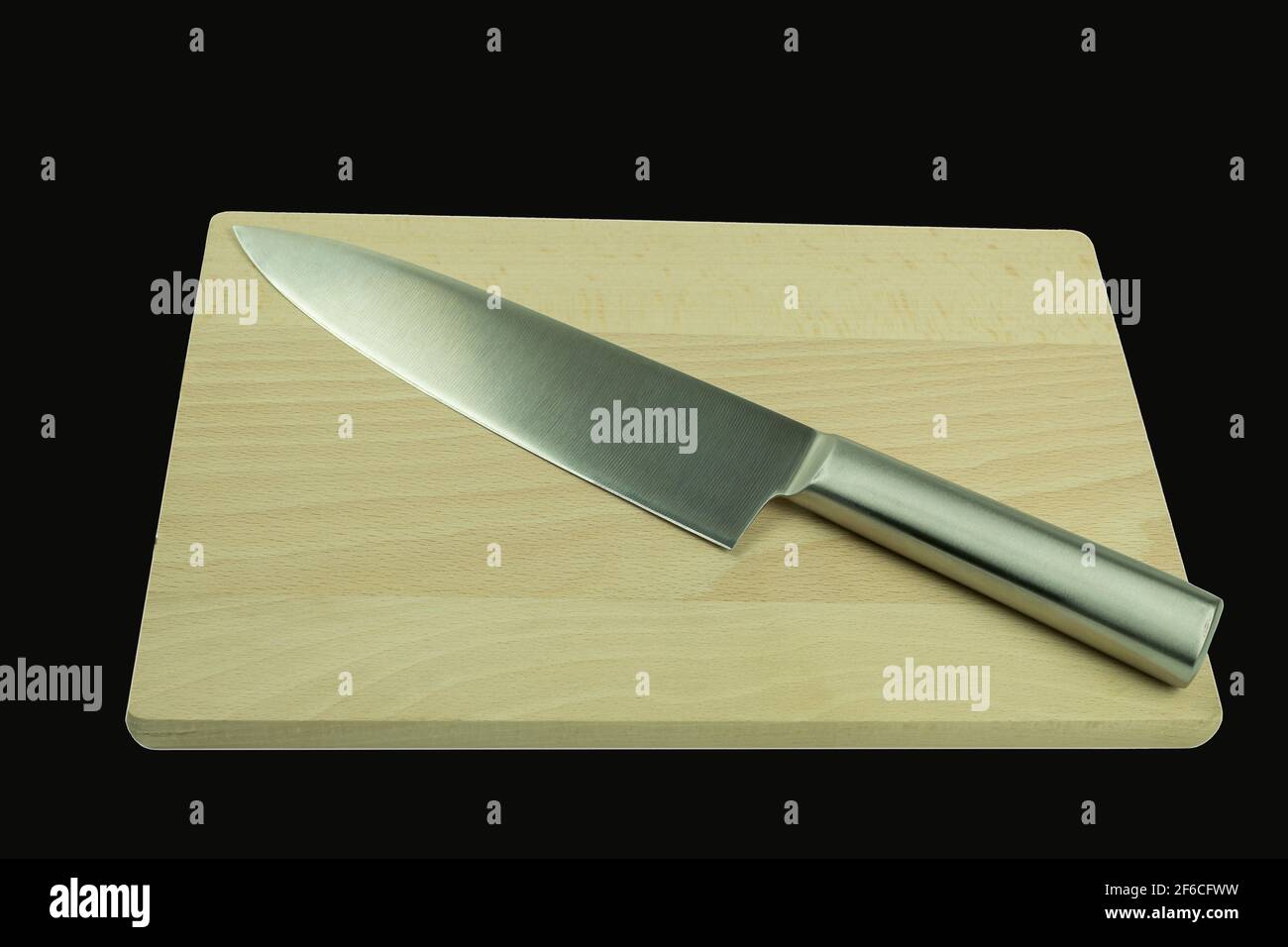 Coltello da cucina in metallo e tagliere in legno su sfondo nero isolato. Coltello professionale dello chef con lama illuminata uniformemente su uno sfondo bianco Foto Stock