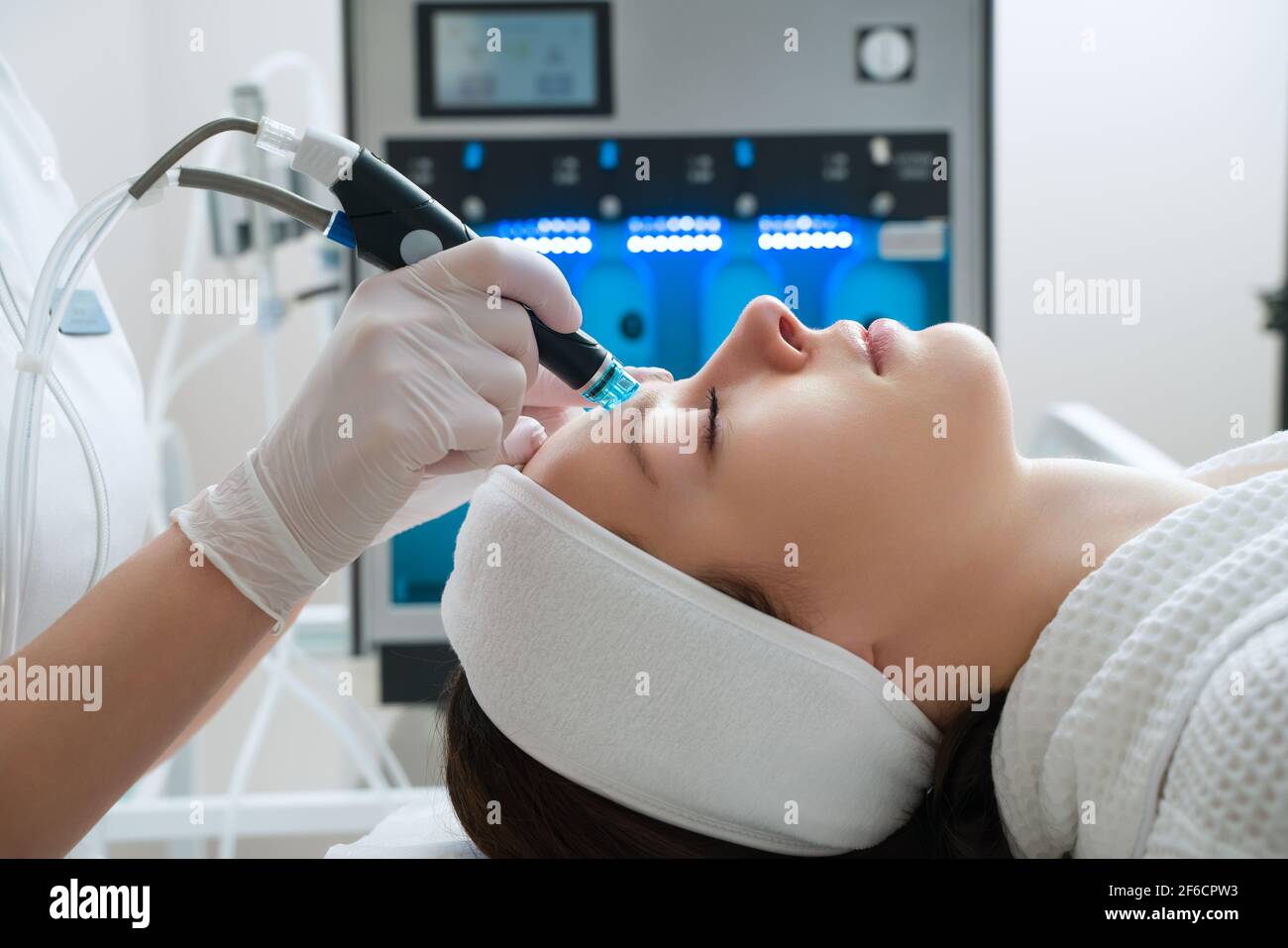 Una donna riceve il trattamento laser del viso in una clinica cosmetologica, un concetto di ringiovanimento della pelle è in fase di sviluppo. Laser peeling. Foto Stock