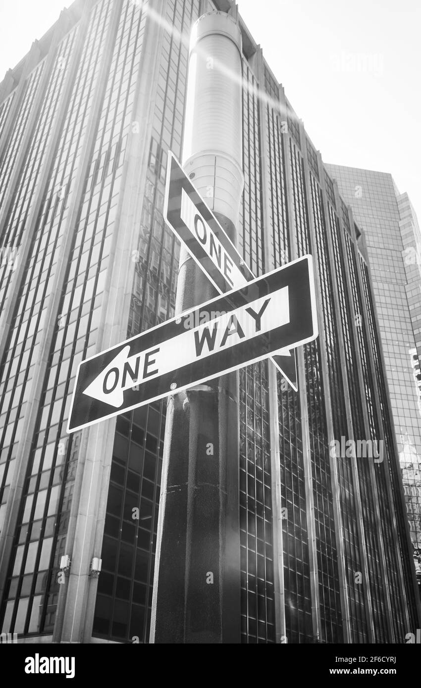 Cartelli stradali a senso unico su un lampione con lente di luce, New York City, USA. Foto Stock