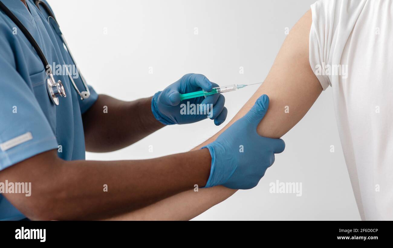 Il personale medico fa l'iniezione al muscolo del braccio per costruire l'immunizzazione di coronavirus covid-19 Foto Stock