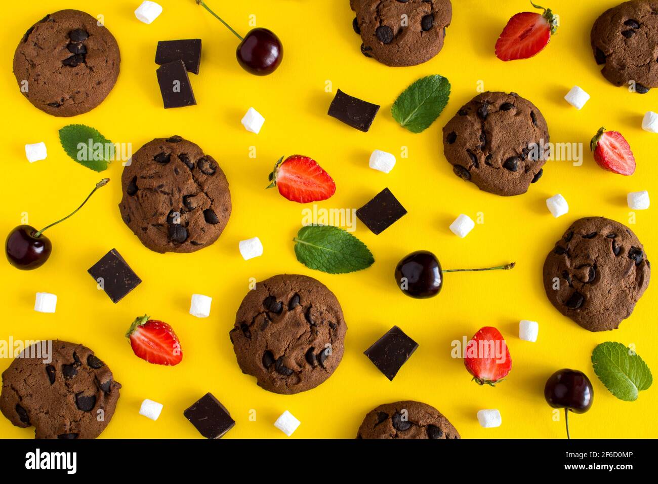 Piatto, vista dall'alto biscotti al cioccolato con frutta sul giallo sfondo Foto Stock