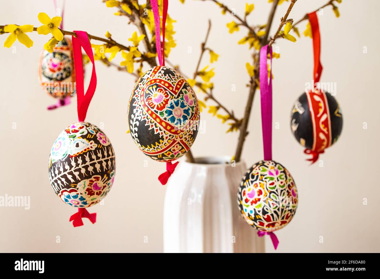 La sistemazione delle tradizionali uova di Pasqua 'Blatnice' decorate da Marie Cihakova e Forsythia fiorente, Brno, Repubblica Ceca, il 30 marzo 2021. (C Foto Stock