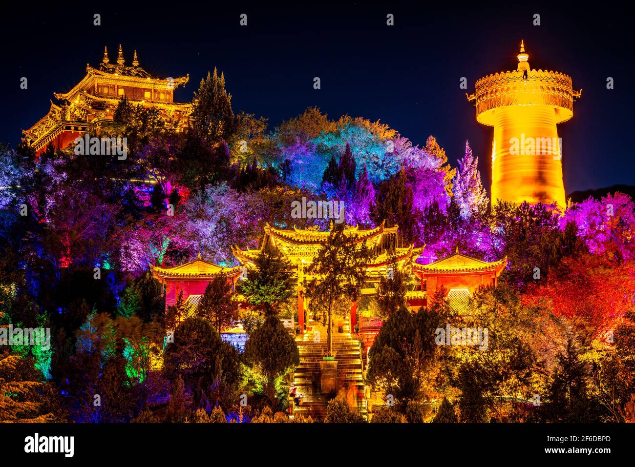 Tempio del Grande Buddha di Guishan Daho con il gigante buddista tibetano ruota di preghiera colorata illuminata durante l'esposizione notturna Shangri-la Yunnan C. Foto Stock