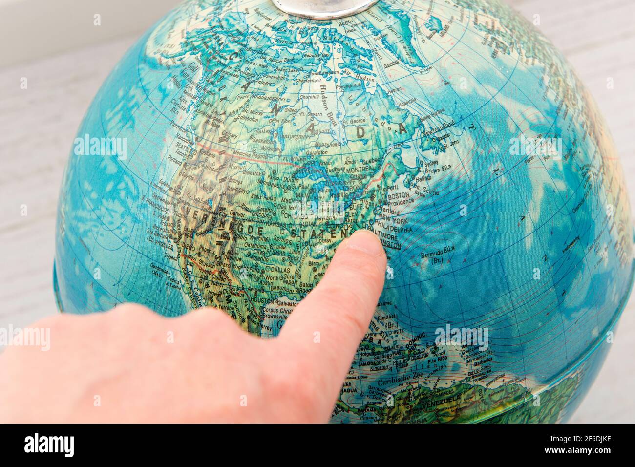 Dito che punta verso la costa occidentale degli Stati Uniti un globo rotondo Foto Stock