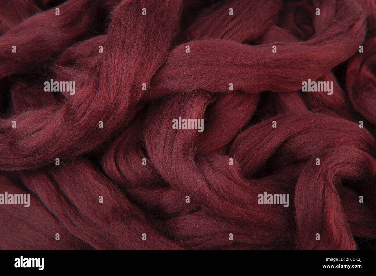 Bella lana merino rosso maroon giacente in paletti sciolti pronti da utilizzare Foto Stock
