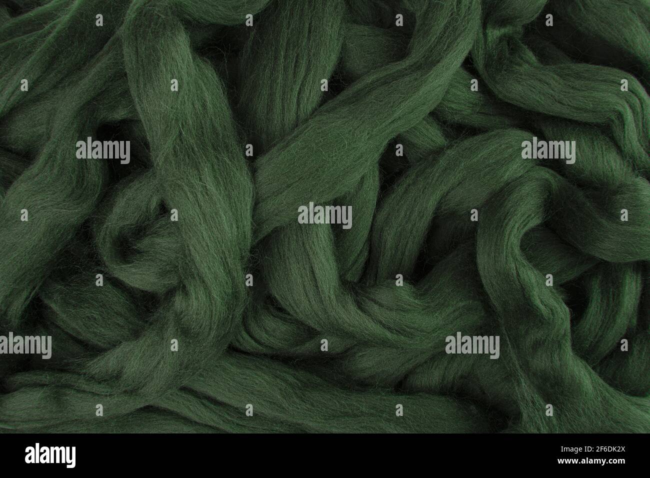 Lana merino verde oliva piuttosto scura giace in stings sciolti pronto per l'uso Foto Stock