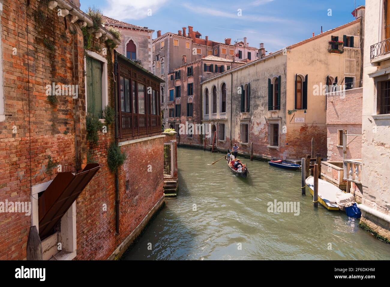 VENEZIA, 23 MAGGIO 2017: Tradizionale strada a canale stretto con gondole e vecchie case a Venezia. Architettura e monumenti di Venezia Foto Stock