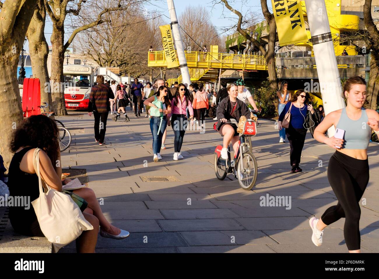 Le persone che godono del sole primaverile sulla South Bank di Londra a seguito dell'allentamento da parte del governo britannico delle restrizioni di Covid che permettono a gruppi di un massimo di sei persone o due famiglie in Inghilterra di incontrarsi all'esterno. Foto Stock