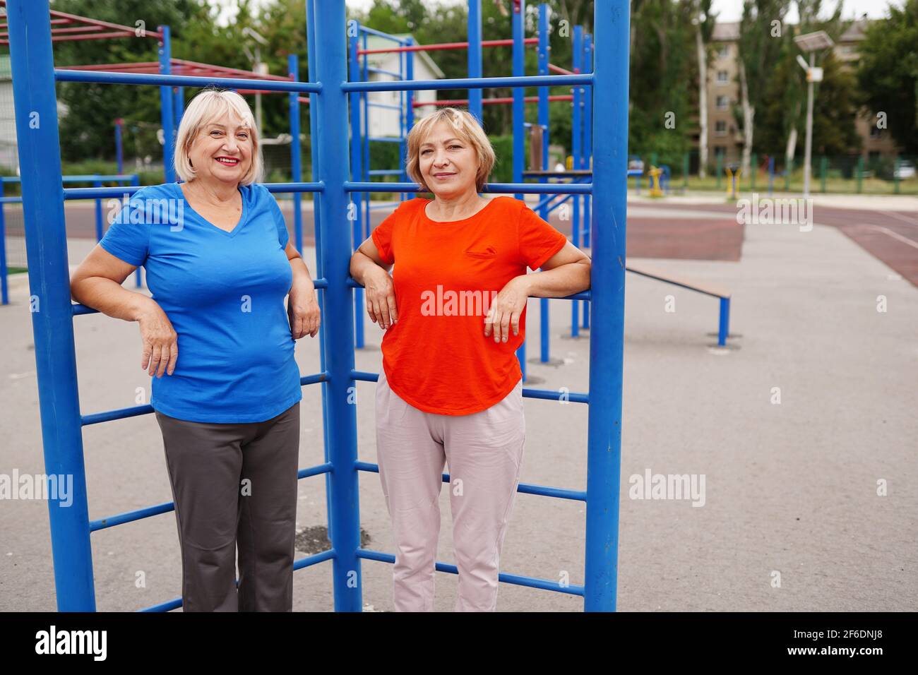 due donne adulte di 58 e 64 anni che fanno esercizi all'aperto sullo stadio Foto Stock