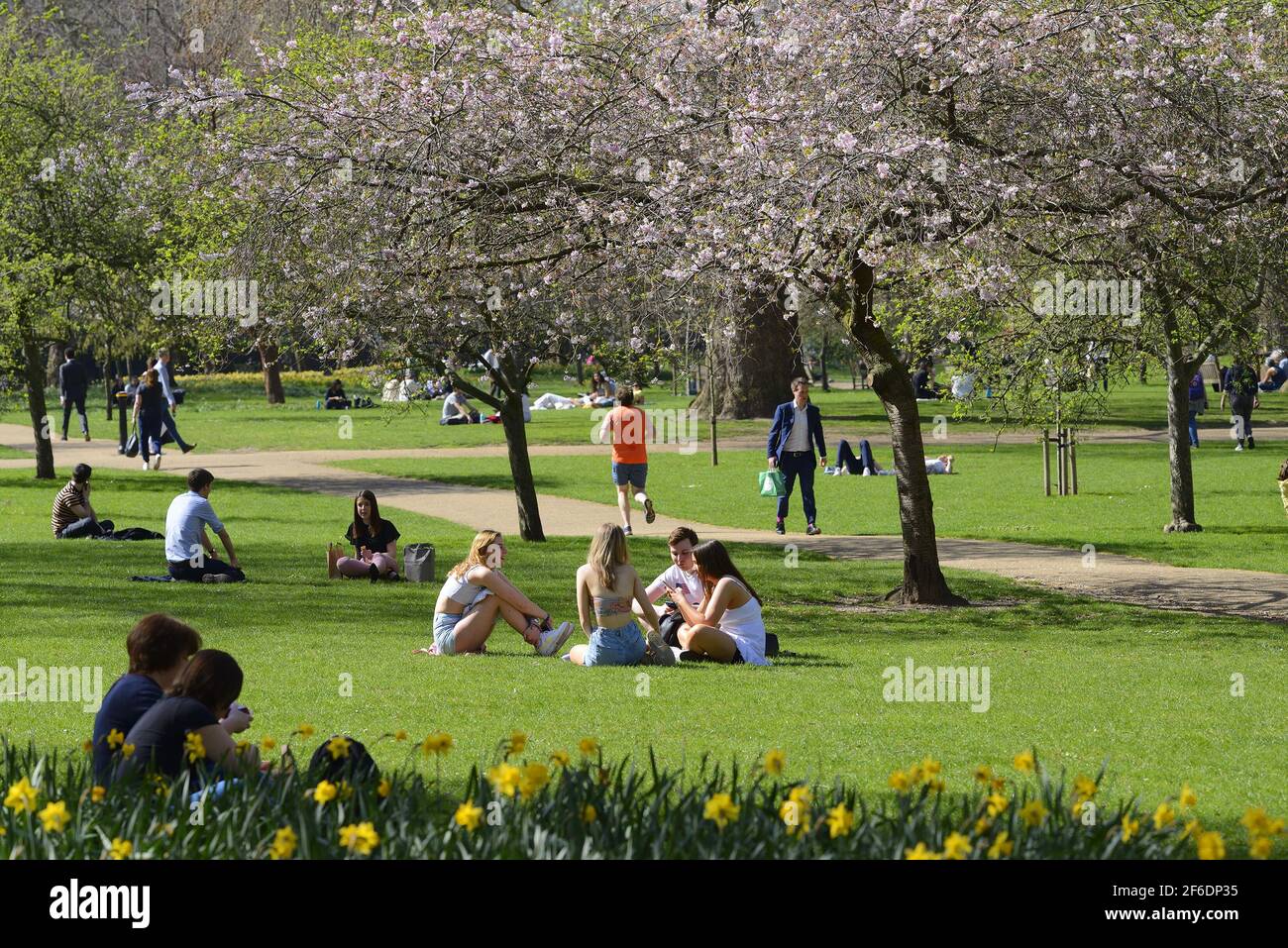 Londra, Inghilterra, Regno Unito. Le persone che godono del sole nel St James's Park a temperature intorno a 23°C il giorno più caldo di marzo in più di 50 anni (30 marzo Foto Stock