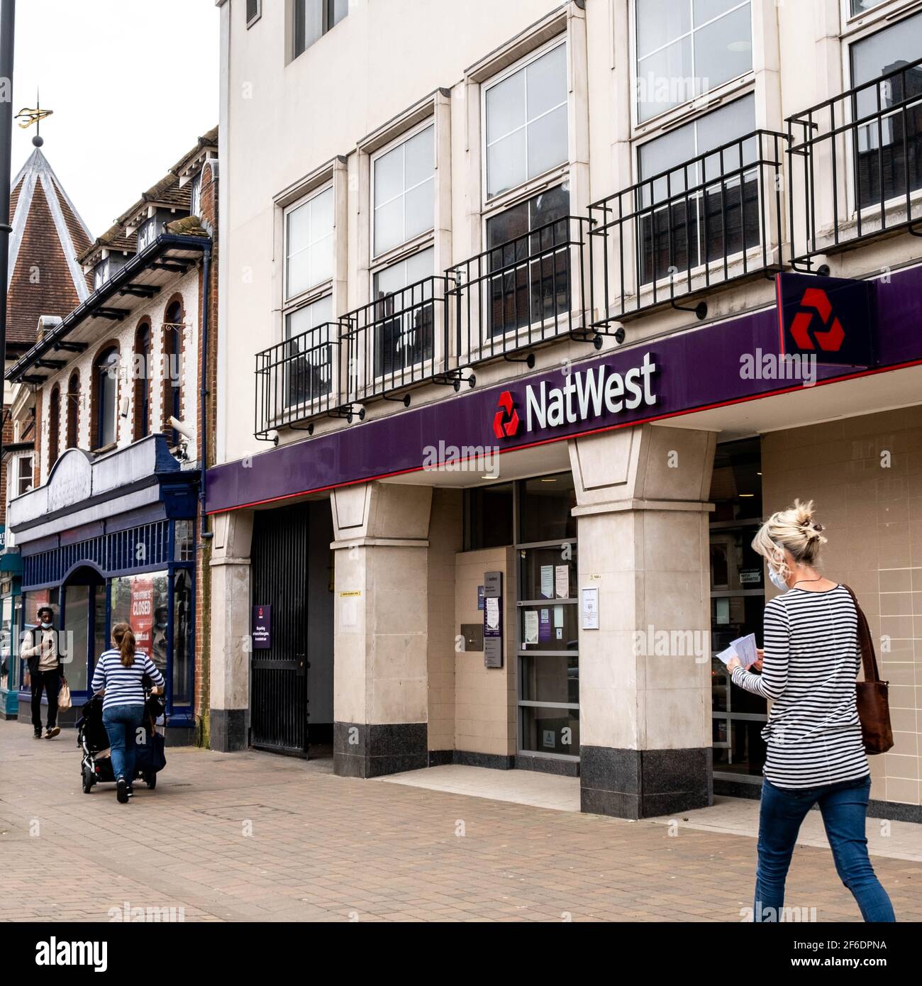 Epsom Surrey London UK, marzo 31 2021, Woman Walking passando accanto A una filiale di High Street della National Westminster Bank Foto Stock