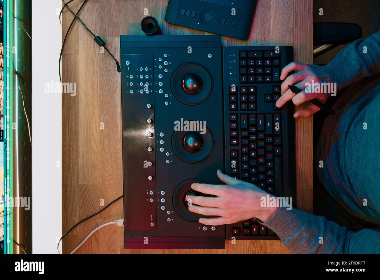 Male Video Editor Hands lavora con filmati o video sul suo pannello di controllo del Personal computer, lavora in Creative Office Studio o a casa. Luci al neon Foto Stock