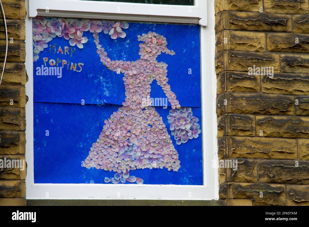 Honley, Holmfirth, Yorkshire, Regno Unito, 31 marzo 2021. Mostra di Alice nel paese delle meraviglie nella finestra del Gallery Cafe, parte del percorso del libro intrecciato di Honley. Utilizzando materiali eco-friendly e riciclati, come i vecchi vestiti/tessuti, gli abitanti del villaggio e le aziende hanno creato una scena o un personaggio da un libro preferito da esporre nel loro giardino o finestra, per creare un percorso locale da Domenica 28 marzo a Lunedi 5 aprile. Questo evento fa parte del Festival della letteratura di Huddersfield e offre premi per i vincitori della zona e un hamper letterario/faodie per un vincitore assoluto. RASQ Photography/Alamy Live News. Foto Stock