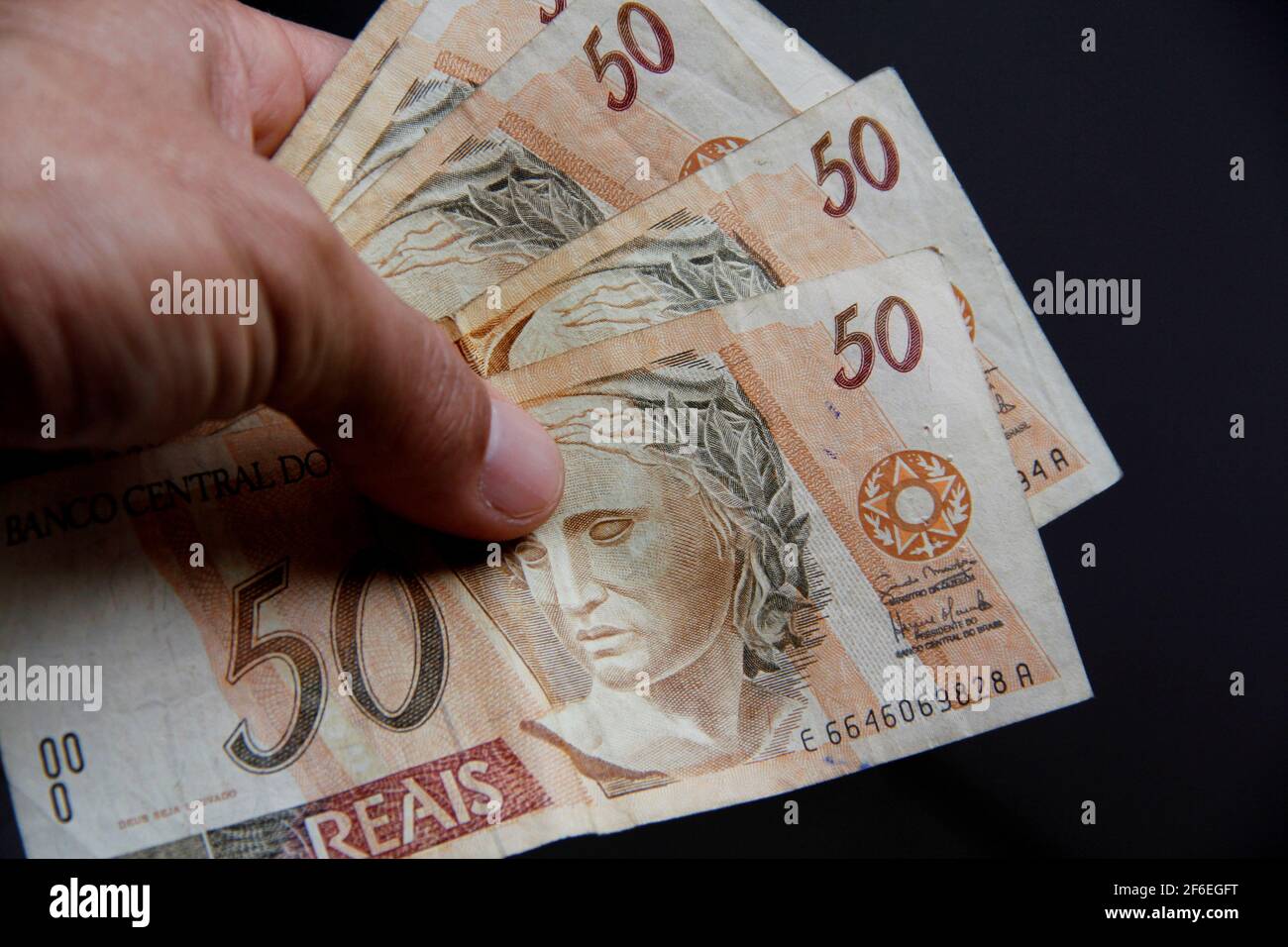 salvador, bahia / brasile - 19 gennaio 2013: Tenere a mano brasiliano banconote in valuta reale. *** Local Caption *** Foto Stock
