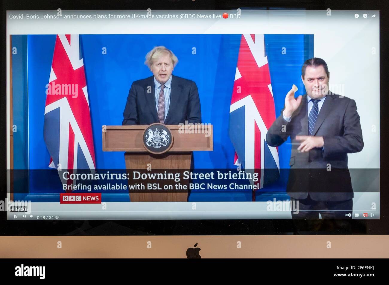 Boris Johnson affiancato da Union Jacks nella nuova sala stampa di Downing Street che fornisce un briefing di Covid. Notizie della BBC. Foto Stock