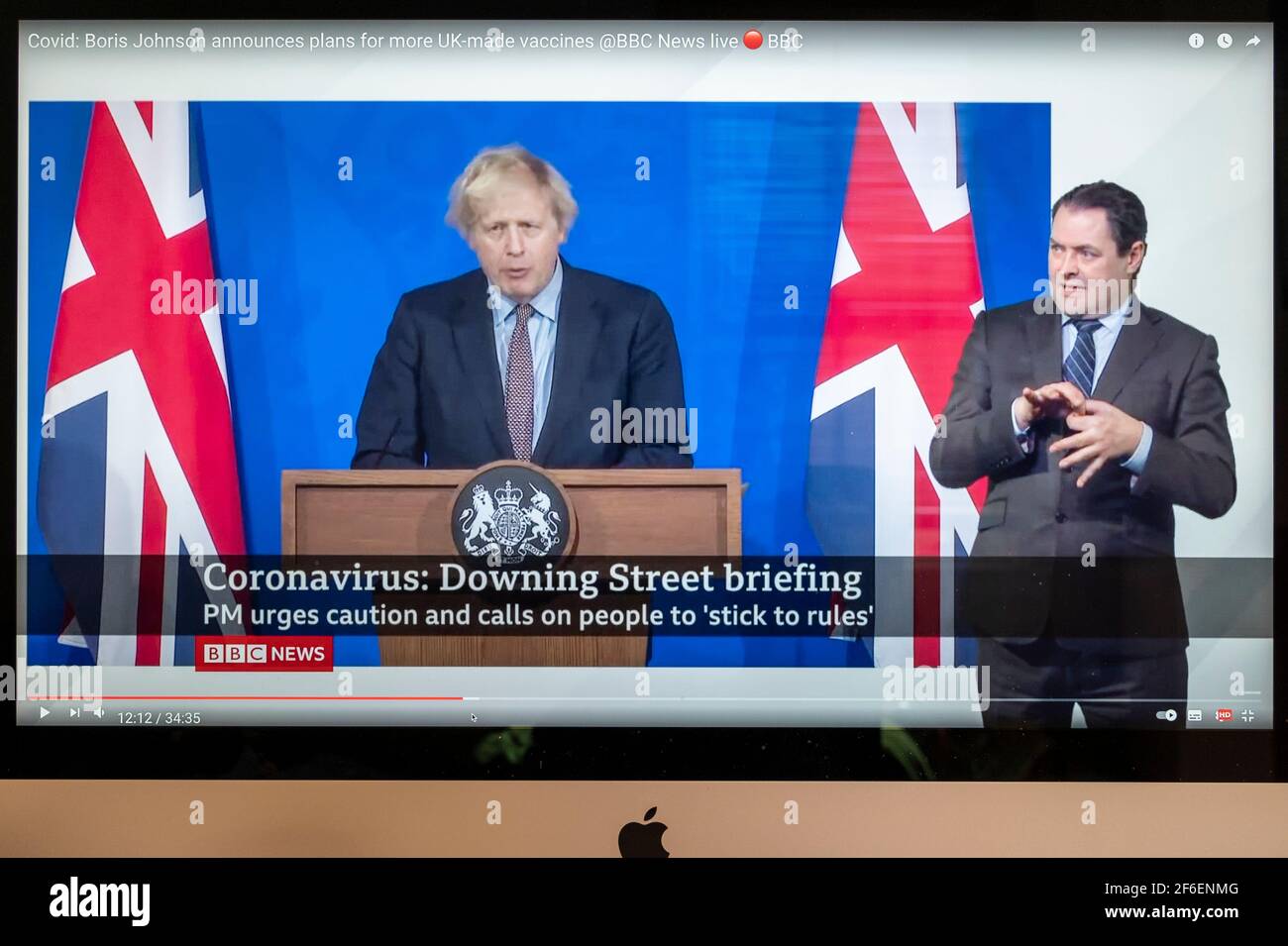 Boris Johnson affiancato da Union Jacks nella nuova sala stampa di Downing Street che fornisce un briefing di Covid. Notizie della BBC. Foto Stock