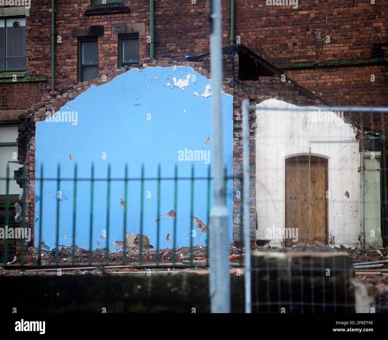 Parete interna esposta di un edificio demolito in una zona di St Helens, Merseyside. Foto Stock