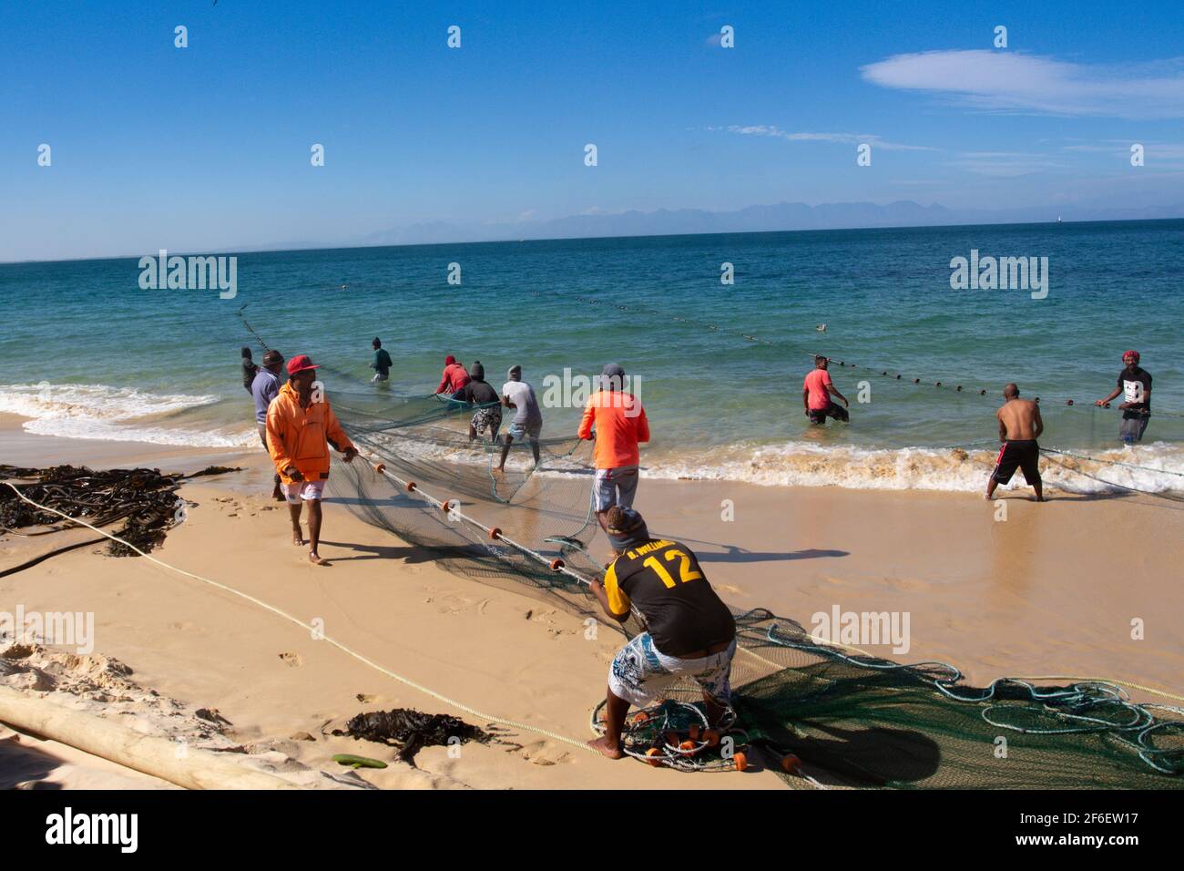 Pescatori che tirano in una grande rete di pesca su Long Spiaggia Capo Peninsulare Città del capo Sud Africa Foto Stock