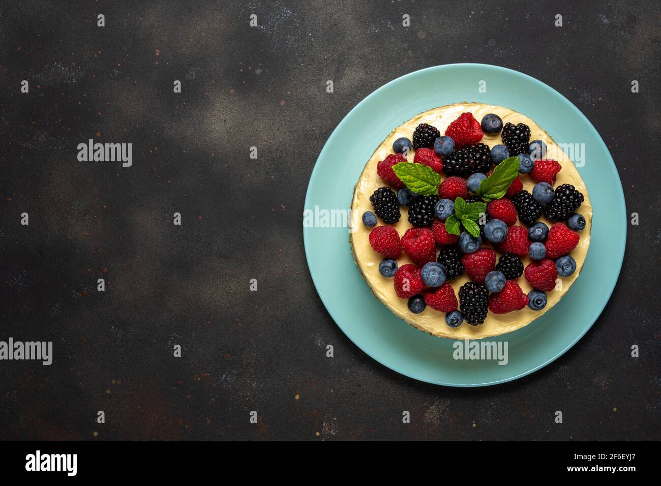 Torta fatta in casa con frutti di bosco freschi su sfondo scuro. Foto Stock