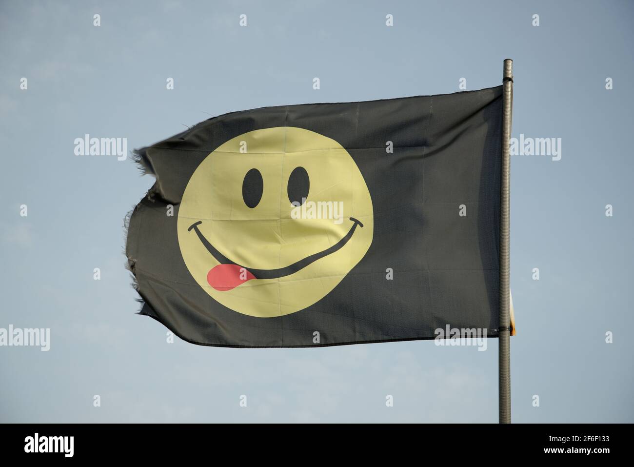 Una bandiera smiley della casa di musica del volto. Happy Face simbolo del festival con una lingua rossa! Yum yum. Foto Stock