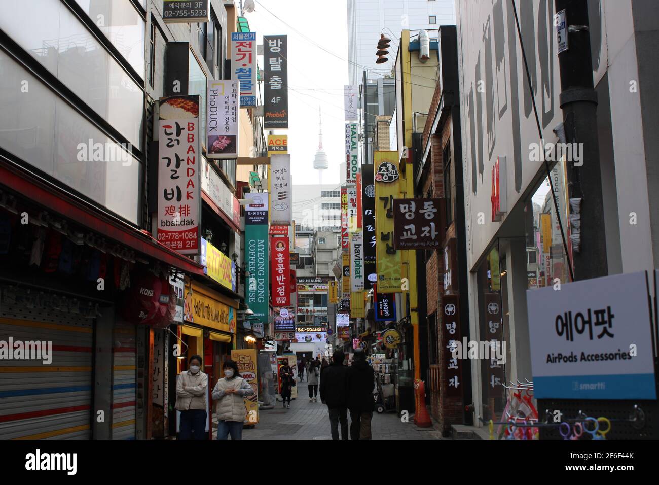 Vicolo commerciale nel centro di Myeongdong, Seoul, con vista a distanza della Torre di Namsan Foto Stock