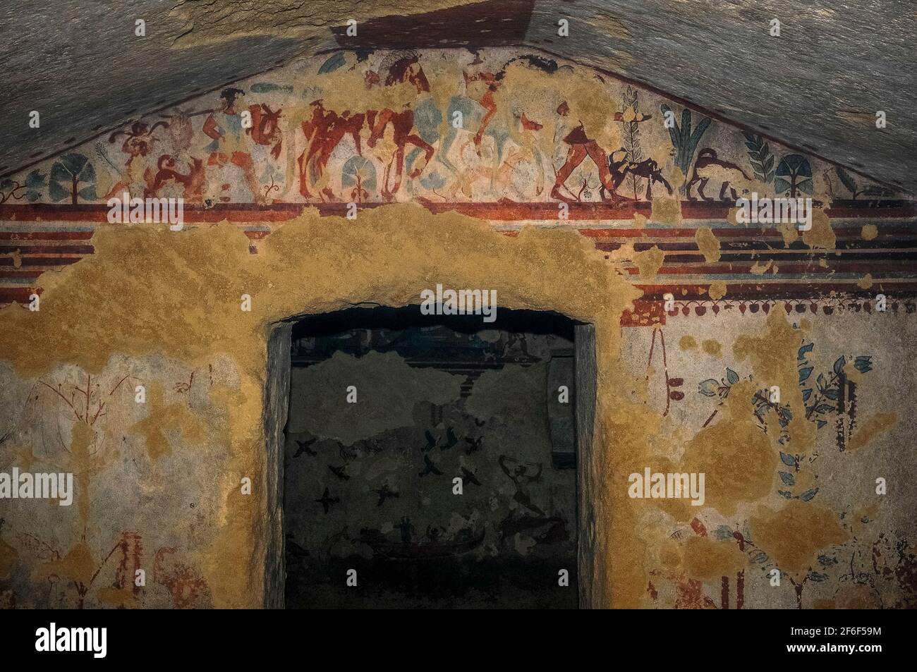 I cacciatori etruschi a cavallo tornano dalla battuta di caccia con servi che trasportano il pescato e cani che corrono accanto ai cavalli. Fregio affrescato sul timpano nella tomba etrusca di 2.500 anni, la Tomba della caccia e pesca, nella necropoli di Monterozzi a Tarquinia, Lazio, Italia. Questa tomba risale al 520-510 a.C. Foto Stock