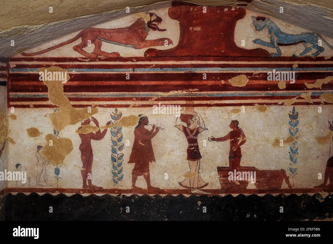 Giochi funerari etruschi: Un giocoliere maschile, un acrobata femminile con una gonna trasparente e un musicista che suona due flauti. Dettaglio tratto dalla pittura murale in una tomba etrusca di 2.500 anni, la Tomba dei Giocolieri, nella necropoli di Monterozzi a Tarquinia, Lazio, Italia. Questa tomba risale al 510 a.C. circa. Il giocoliere regge due dischi mentre si trova davanti a due cesti, mentre l'acrobata femminile bilancia un candelabro dall'aspetto pesante o un candelabro sulla testa. Foto Stock