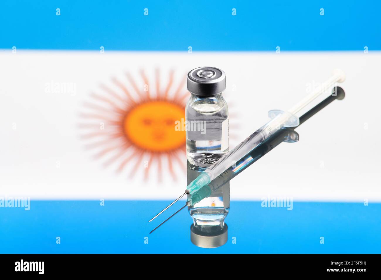 Concetto di vaccino con bandiera argentina riflessa e sfocata, focalizzazione selettiva sul vaccino Foto Stock