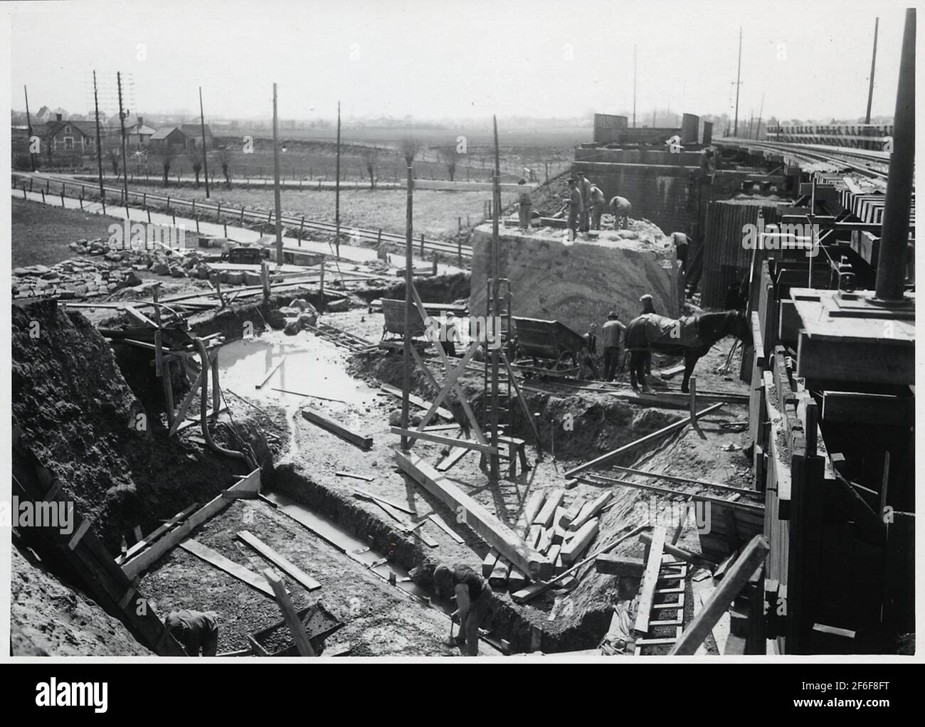 Ricostruire il viadotto attraverso la ferrovia di Malmö Ystad, sulla rotta tra Malmö e Trelleborg. Getto di calcestruzzo per suola alla nuova staffa di terra. Scavo per la base per pendolo e demolizione della vecchia staffa del terreno. Foto Stock