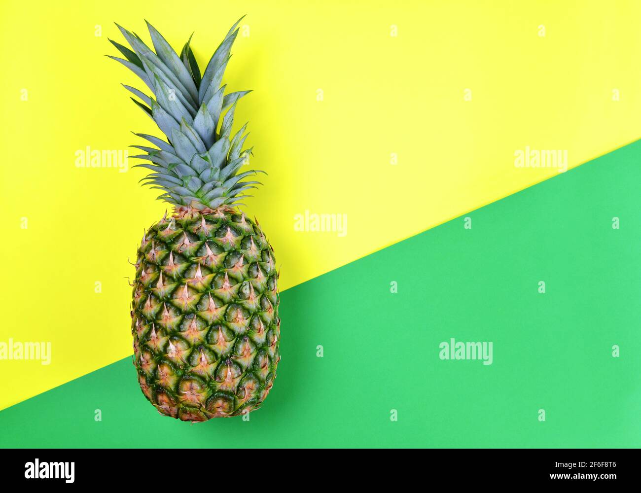 Ananas fresco di frutta tropicale su carta verde e gialla. Foto Stock