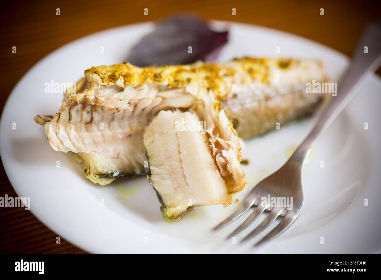 pesce cotto al forno con spezie, spezie in un piatto Foto Stock